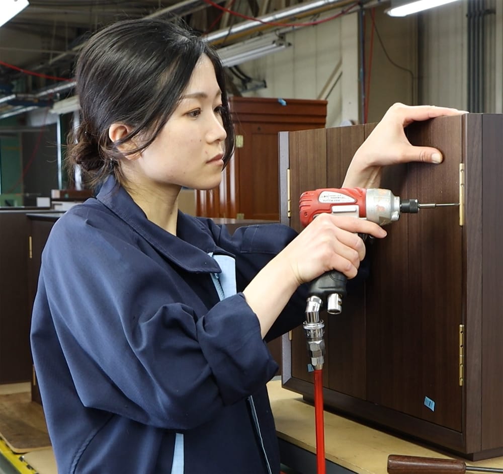 職人がお仏壇の扉を取り付ける作業をしているイメージ